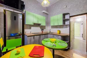 una cucina con armadi verdi e tavolo giallo di Hostel Vokzalnaya a Kiev Altre 28 foto