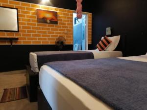 een slaapkamer met 2 bedden en een bakstenen muur bij Summer Villa Apartment Ella in Ella