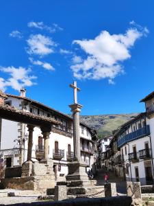 une croix au sommet d'un monument d'une ville dans l'établissement Casa Rural Puerta del Sol II de 2 habitaciones, à Candelario