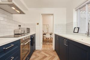 達靈頓的住宿－The Derwent，厨房配有蓝色橱柜和水槽