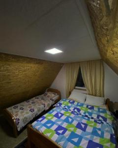 um pequeno quarto com uma cama num quarto em Vikendica Amra i Indir em Travnik