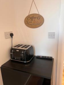 a toaster sitting on top of a black table at 1 Bedroom & Bathroom (No kitchen) (Garden) (Driveway) in Dorney