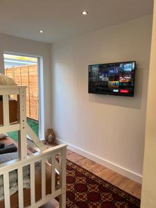 a living room with a flat screen tv on the wall at 1 Bedroom & Bathroom (No kitchen) (Garden) (Driveway) in Dorney