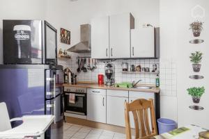 eine Küche mit weißen Schränken und einem blauen Kühlschrank in der Unterkunft StayINN Lindenau in Leipzig