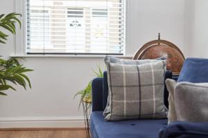 salon z niebieską kanapą i oknem w obiekcie The Derwent w mieście Darlington