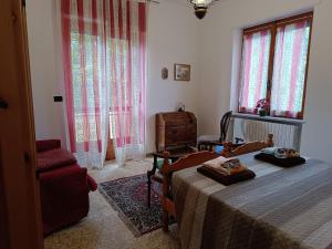 a bedroom with a bed and a chair and windows at Grazioso bilocale Merlino, luminoso con vista Santuario, wifi in Giaveno