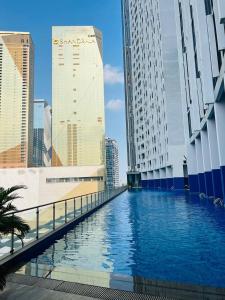 a swimming pool in a city with tall buildings at ImPian 1BR condo in Phnom Penh