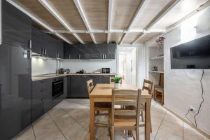 a kitchen with a table and chairs in a room at Duomo 10 minutes away - Loft with Wifi and Netflix in Milan