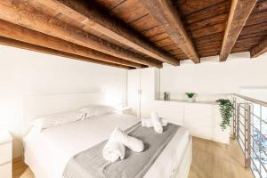 a white bedroom with white walls and wooden ceilings at Duomo 10 minutes away - Loft with Wifi and Netflix in Milan