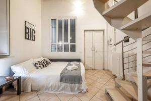 a white bedroom with a bed and a staircase at Duomo 10 minutes away - Loft with Wifi and Netflix in Milan