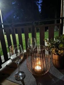 a table with wine glasses and a candle on it at Cozy Riverside Pine Studio E5 in Borovets