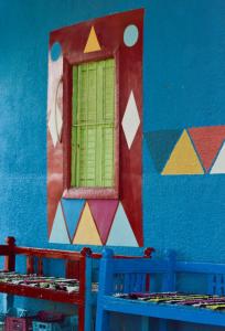 una ventana en una pared azul con una ventana en Heissa Hostel, en Asuán