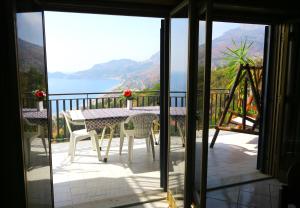 a balcony with a table and chairs and a view of the water at Collina del Sole in Letojanni