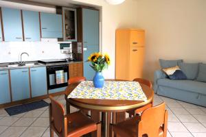 a kitchen and a table with a vase of flowers on it at Collina del Sole in Letojanni