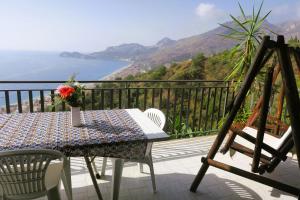 a table and chairs on a balcony with a view of the ocean at Collina del Sole in Letojanni +74 photos