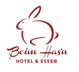 una imagen de un logotipo para un hotel y un complejo en Beim Has’n en Rimsting