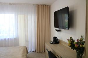 a hotel room with a television on the wall at Dom Gościnny Posejdon in Pobierowo