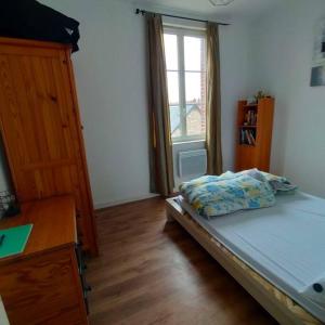 1 dormitorio con 1 cama, vestidor y ventana en Maison de pêcheur proche du port,plage et commerces chez SAJA, en Fécamp