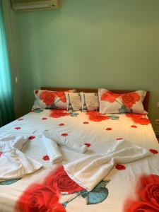 uma cama com lençóis vermelhos e brancos e rosas em Apartament Crăciunița em Timisoara