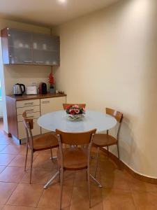 uma cozinha com uma mesa com cadeiras e uma tigela de flores em Apartament Crăciunița em Timisoara
