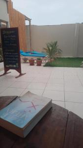 un libro sentado en una mesa junto a un cartel en Hostel Willys House, en Paracas