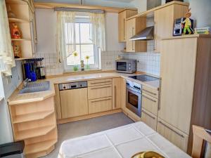 a small kitchen with wooden cabinets and a window at Ferienwohnung Schneider in Ruhstorf