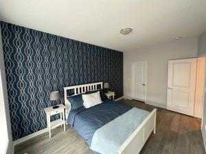 1 dormitorio con cama y pared azul en Modern Townhouse, Vaughan, Ontario, Canada, en Vaughan