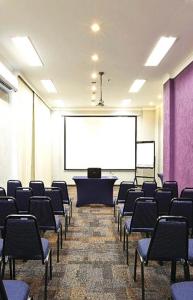 een conferentieruimte met stoelen en een projectiescherm bij HOTEL PERDIZES - FLAT Executivo - 1204 in Sao Paulo