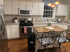 een keuken met witte kasten en een fornuis met oven bij Cape Cod Loft - Room near Liberty! in Lynchburg