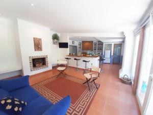 sala de estar con sofá azul y cocina en Casa da Gralheirinha, en Santana do Mato