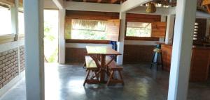 Habitación con mesa de madera y algunas ventanas. en Casa Gaviota en Mazunte