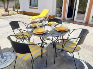 una mesa y sillas con sillas amarillas en el patio en Casa da Gralheirinha, en Santana do Mato