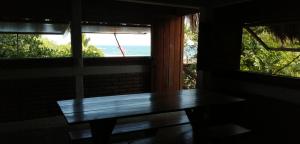 a wooden bench in a room with two windows at Casa Gaviota in Mazunte