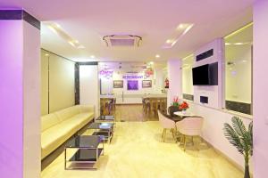 a living room with a couch and a table and chairs at Hotel De Clark Residency Delhi Airport in New Delhi