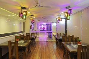 un comedor con mesas, sillas y luces en Hotel De Clark Residency Delhi Airport en Nueva Delhi