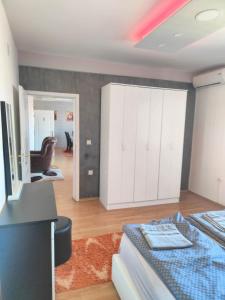 a bedroom with a bed and a white cabinet at Apartman Aleksandar, BN centar in Bijeljina