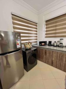 Il comprend une cuisine équipée d'un réfrigérateur en acier inoxydable et d'une cuisinière. dans l'établissement Dar R’YAH Appartement - Tamraght, Taghazout, à Agadir