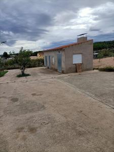 a small building with blue doors in a parking lot at REFUGIO La Pared in La Pared