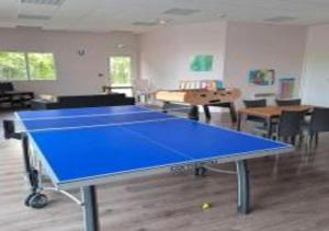 una mesa de ping pong azul en una habitación en De la détente dans ce coin de campagne., en Équemauville