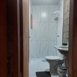 a bathroom with a shower and a toilet and a sink at Casa para temporada em Arroio do Silva a 900m do mar in Arroio do Silva