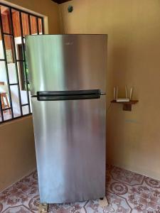 a stainless steel refrigerator in a room with a window at Surf Shack Room #1 in Pavones