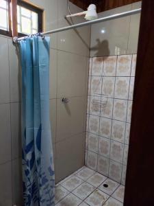 um chuveiro com uma cortina de chuveiro azul na casa de banho em Surf Shack Room #1 em Pavones