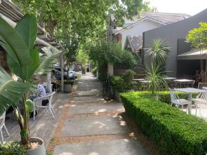 a sidewalk with plants and tables and chairs at AQUI ES!!! in Banfield