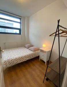 Schlafzimmer mit einem Bett, einem Schreibtisch und einem Fenster in der Unterkunft Le CARNOT appartement avec 2 chambres séparés et parking privatif et securise in Arras