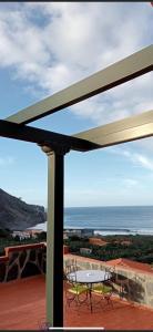 a table and chairs on a deck with a view of the ocean at Casa Rural Ondina in Hermigua