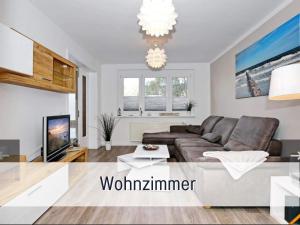 uma sala de estar com um sofá e uma televisão em 2 Zimmer App Dünengarten Lieblingsplatz Wg11 em Kühlungsborn