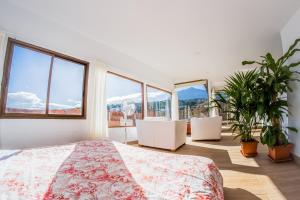 ein Schlafzimmer mit einem Bett und einigen Pflanzen und Fenstern in der Unterkunft Espacio Antares in Icod de los Vinos