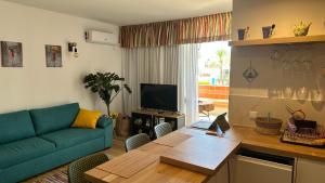 a living room with a couch and a table with a laptop at Air-Conditioned, Remarkably Beautiful Apartment, Fibre Wi-Fi, Pool in Arona