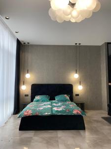 una camera con letto e lampadario a braccio di Apartment Delmar Lux ЦЕНТР a Dnipro