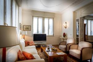 een woonkamer met witte meubels en een televisie bij Villa Cernobbio in Cernobbio